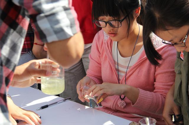 现场志愿者帮助同学制作琥珀