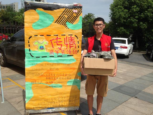 拿着军装露出愉快笑容的志愿者